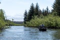 People paddling a boat on a river surrounded by greenery in Yakutat, Alaska