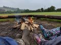 3 people in pairs of Wellington boots sitting around a campfire Royalty Free Stock Photo