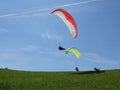 People paragliding in a free fly in Europe in Alps mountains with blue sky in the background Royalty Free Stock Photo