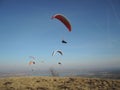 People paragliding in a free fly in Europe in Alps mountains with blue sky in the background