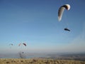 People paragliding in a free fly in Europe in Alps mountains with blue sky in the background