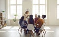 People participating in group therapy for social skill training in bright office