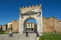 People pass under Augustus Arch - the ancient romanesque gate and the historical landmark of Rimini, Italy.