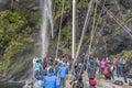 People on passenger vessel deck at waterfall, Milford Sound, New Zealand