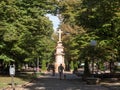 People passing by the calvary and catholic cross of the Trg Kralja Petra I square, the main square of Pancevo Royalty Free Stock Photo