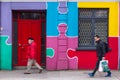 People passing by colorful building