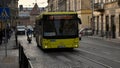 People passing by old Lviv city street with busy traffic