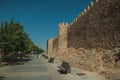 People on pedestrian promenade beside large city wall at Avila