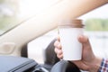 People person business man drinking paper cup coffee of hot in hand while driving in a car in the Morning sunlight Royalty Free Stock Photo