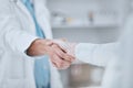 People, pharmacist and handshake in meeting, teamwork or agreement together for deal at pharmacy. Closeup of medical or Royalty Free Stock Photo