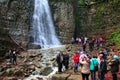 People are photographed against the background of the Manyavskii waterfall