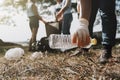 people picking up garbage and putting it in plastic black bag for cleaning Royalty Free Stock Photo