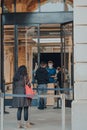 People picking up orders outside Apple Store in Covent Garden, London, UK, staff and customer wearing face shields PPE