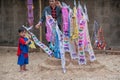 People pin traditional flags on sand pagoda