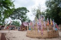 People pin traditional flags on sand pagoda