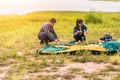 People Pitch a tent on the ground near the lake at sunset. Relaxing, traveling, long weeked, holiday concept Royalty Free Stock Photo