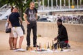 several people and two are putting candles into the sand at the beach Royalty Free Stock Photo