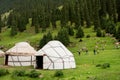 People play games outdoor near the asian farmers houses Yurts in Central Asian mountains