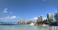 People play in the protected water and hang out on the beach with sand restoration project in progress in the distance Royalty Free Stock Photo