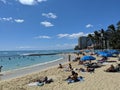 People play in the protected water and hang out on the beach in Waikiki Royalty Free Stock Photo