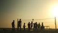 People play volleyball on the beach at sunset. Royalty Free Stock Photo