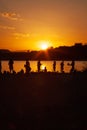 People play volleyball on the beach during the sunset