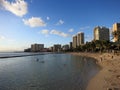 People play in water and beach in Waikiki at dusk Royalty Free Stock Photo