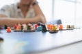 People playing board game on board game field with many figure, meeple, dice, models at home. Playing game with friends, family, Royalty Free Stock Photo