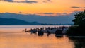 People playing on the shore under dramatic panorama evening sky