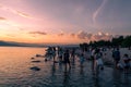 People playing on the shore under dramatic panorama evening sky