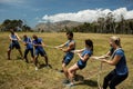 People playing tug of war during obstacle training course Royalty Free Stock Photo