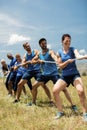 People playing tug of war during obstacle training course Royalty Free Stock Photo