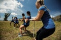 People playing tug of war during obstacle training course Royalty Free Stock Photo