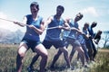 People playing tug of war during obstacle training course Royalty Free Stock Photo