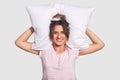 People and pleasure concept. Lovely satisfied woman with charming smile, keeps pillow behind head, being in high spirit, has enoug