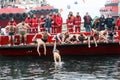 People plunge to retrieve a wooden cross thrown into the sea, du