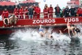 People plunge to retrieve a wooden cross thrown into the sea, du