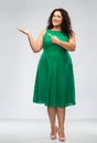 Happy woman in green pointing fingers at something