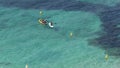 People practice sports in Portals Nous beach in Mallorca detail