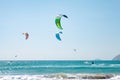 People practicing Kitesurfing. Beach on the peninsula Prasonisi, Rhodes. Colorful kites on the sea shore. Blue sea and