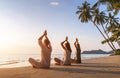 People practicing yoga on the beach, wellbeing, warm tropical landscape