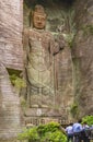 People praying at the foot of the Hyaku-shaku kannon buddha carved in Mount Nokogiri. Royalty Free Stock Photo