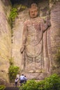 People praying at the foot of the Hyaku-shaku kannon buddha carved in Mount Nokogiri.