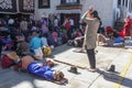 People praying in prostration in front of Jokhang temple in Lhasa on Barkhor square, Tibet - one woman standing