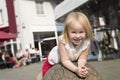 People , pretty litlle girl three on a crowded street. Summer sunny weather