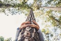 People protecting trees from deforestation concept with couple of senior caucasian hands hugging with love a pine in the wood -