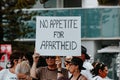 People protesting Covid-19 vaccine mandates, man holding large placard saying no appetite for apartheid.