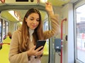 People on public transport. Young business woman reading message on her smart phone on the tram Royalty Free Stock Photo