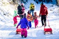 People are pulling sledge on the mountain road in woods. Royalty Free Stock Photo