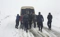 People pushing stuck car in snowy mountain Royalty Free Stock Photo